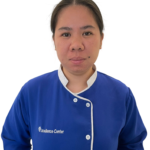 Staff member portrait in a blue uniform with white trim, against a white background, with 'Excellence Center' logo on the chest.