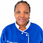 Portrait of a smiling woman in a blue uniform with white trim, standing against a white background.