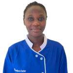 Portrait of a smiling Black woman in blue medical scrubs with white trim, Excellence Center logo on her chest.