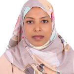 Portrait of a woman wearing a pastel patterned hijab facing the camera against a white background, neutral expression.