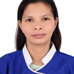 Portrait of a woman in a blue medical uniform with white collar, neutral expression, facing the camera.