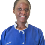 Smiling woman in a blue medical uniform with white trim, facing the camera.