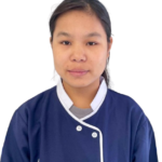 Portrait of a woman facing the camera, wearing a navy blue chef-style uniform with white trim against a white background.