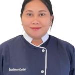 Portrait of a smiling woman in a navy uniform with white trim, featuring an 'Excellence Center' logo on the left chest.