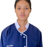 Portrait of a young woman in a blue uniform with white trim against a white background, facing the camera with a neutral expression from the shoulders up.