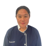 Portrait of a woman in a navy blue uniform with white trim, facing the camera and smiling slightly.