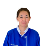 Portrait of a smiling woman in a blue uniform with white trim, against a white background.
