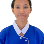 Portrait of a young woman in a blue uniform with a white collar, facing the camera.