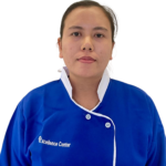 Portrait of a woman wearing a blue uniform with white trim, facing the camera; the uniform displays the 'Excellence Center' logo on the chest against a white background.